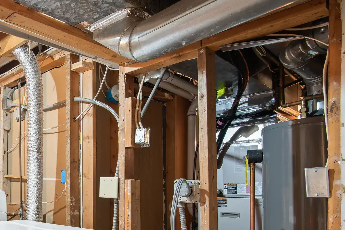 Furnace, sheet-metal ductwork and a water heater in an unfinished basement utility area